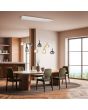 Sfeerfoto van 125 cm lange Trio Aldea hanglamp met witte plafondbalk en acht pendels met amber en rookglazen kappen met wit glazen binnenschaal boven een grote eettafel