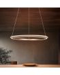 Trio Amador 331019165 sfeerfoto van koffiebruine cirkelvormige hanglamp van 75cm in diameter met twee lichtringen en schakelaar voor de kleurtemperatuur boven een houten eettafel