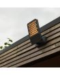 Sfeerfoto van Lutec Atlantis antraciet grijze schijnwerper van 22,2 cm diep met honingraat structuur voor de LED unit op een houten dakrand