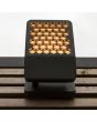 Sfeerfoto van Lutec Atlantis antraciet grijze schijnwerper van 22,2 cm diep met honingraat structuur voor de LED unit op een houten dakrand