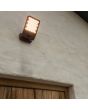 Sfeerfoto van Lutec Atlantis antraciet grijze schijnwerper van 22,2 cm diep met honingraat structuur voor de LED unit en bewegingsmelder boven een staldeur