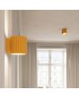 sfeerfoto van geel geribbelde metalen wandlamp met een diameter van 10 cm en een G9 fitting in een woonkamer