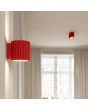 sfeerfoto van een rood geribbelde metalen wandlamp met een diameter van 10 cm en een G9 fitting in een woonkamer