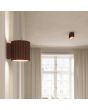 sfeerfoto van bruin geribbelde metalen wandlamp met een diameter van 10 cm en een G9 fitting in een woonkamer