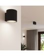 Sfeerfoto van Sollux Aura zwart geribbeld cilindervormige wandlamp van 10 cm in hoogte met een G9 lampje erin voor een plafondlamp uit dezelfde serie