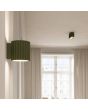 Sfeerfoto van Sollux Aura olijf groen geribbeld cilindervormige wandlamp van 10 cm in hoogte met een G9 lampje erin in een woonkamer met plafondlamp uit dezelfde serie