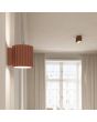 Sfeerfoto van Sollux Aura mokka bruin geribbeld cilindervormige wandlamp van 10 cm in hoogte met een G9 lampje erin in een woonkamer met een plafondlamp uit dezelfde serie