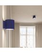 Sfeerfoto van Sollux Aura marine blauw geribbeld cilindervormige wandlamp van 10 cm in hoogte met een G9 lampje erin in een woonkamer met een plafondlamp uit dezelfde serie