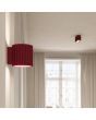 Sfeerfoto van Sollux Aura burgundy geribbeld cilindervormige wandlamp van 10 cm in hoogte met een G9 lampje erin in een woonkamer met plafondlamp uit dezelfde serie