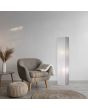 Sfeerfoto van Trio Bamboo rechthoekige vloerlamp van 130 cm hoog van wit rijstpapier met twee lichtpunten naast een beige kuipstoel