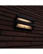 Sfeerfoto van Lutec Barlo antraciet grijze platte wandlamp van 20,8 cm breed en slechts 7,3 cm diep met dubbel zonnepaneel