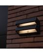 Sfeerfoto van Lutec Barlo antraciet grijze platte wandlamp van 20,8 cm breed en slechts 7,3 cm diep met dubbel zonnepaneel