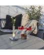 Sfeerfoto van Konstsmide Biarritz vaasje van 20,5 cm hoog met staalkleurige voet en mat glazen buisje met LED onderin op een tuintafel