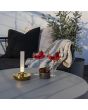 Sfeerfoto van Konstsmide Biarritz vaasje van 20,5 cm hoog met messingkleurige voet en mat glazen buisje met LED onderin op een grijze tuintafel