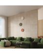 Sfeerfoto van drie ronde wandlampen Borgen van 30 cm in diameter voor indirect licht langs de muur in een moderne woonkamer met groene hoekbank