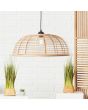 Sfeerfoto van Brilliant Crosstown 99261/06 hanglamp met zwarte pendel en grote ronde kap van bamboe spijlen voor een wit stenen muur