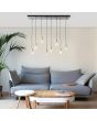 Brilliant Darcia 99815/06 sfeerfoto van hanglamp met brede plafondbalk en acht pendels met klassieke mat messing fittingen en titanium lichtbronnen boven een zithoek met blauw stoffen bank