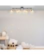 Brilliant Kerry 99716/76 sfeerfoto van plafondspot met twee zwarte stangen met elk drie spots met bamboe houten fittinghouder en goudkleurig E27 peertje in een kinderkamer
