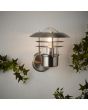 Brilliant Terrence 45781/82 Sfeerfoto van RVS buitenwandlamp met transparant glas met lamellen ervoor aan buitenmuur