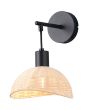 Brandende Casalum Calvi zwarte wandlamp met hangende kap van rotan en kiepschakelaar op het wandplaatje