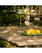 Sfeerfoto van Konstsmide Capri grijsgroene tafellamp op batterijen van 37 cm hoog en touch dimmer op de kop op een houten tuintafel naast een schaal met citroenen