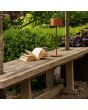 Sfeerfoto van Konstsmide Capri terracotta kleurige tafellamp op batterijen van 37 cm hoog en touch dimmer op de kop op een houten tuinbankje naast een boek