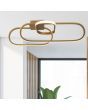 Searchlight Clip 61774GO sfeerfoto van goudkleurige plafondlamp van 65cm met drie ovale ringen in elkaar met LED strip aan de buitenzijde aan een rechthoekige plafondplaat voor een raam