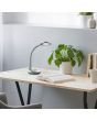Trio Cobra R52721187 sfeerfoto van zilvergrijs bureaulampje met flexibele hals en platte ronde kop met LED unit op een houten bureau
