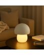 Sfeerfoto van de Brilliant Dupis witte kunststof oplaadbare tafellamp met LED in de voet en wit metalen ovale kap, met een hoogte van 23,8 cm en een diameter van 20 cm op een houten salontafel