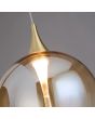 LED unit van de wandlamp met zwarte ophanging van 26cm hoog met hangende kap met goudkleurige bovenzijde en een obre amber kleurige glazen bol met geïntegreerde LED