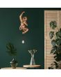 Sfeerfoto van Reality Fips hanglamp met een goudkleurig aapje van 38 cm hangend aan het snoer met een koperkleurige fitting met E14 kogellampje voor een groene muur met een houten kamerscherm en wat groene planten