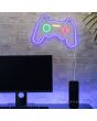 Sfeerfoto van de brandende Gamer wandlamp in de vorm van een console. De lamp is 41 cm breed en verbruikt 5w. Het licht is blauw, groen, geel en rood aan de muur boven een computer