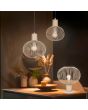 Trio Gila 565700166 sfeerfoto van zand kleurige tafellamp met bolvormige kap van metaaldraad op een kastje met twee hanglampen uit dezelfde serie