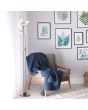 Searchlight Gio EU1024SNCC sfeerfoto van staal kleurige uplighter van twee kantelbare halve circels en rond leeslampje aan een flexibele arm voor een raam en naast een stoel voor een wand met schilderijen van bladeren