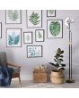 Searchlight Gio EU1024MBSB sfeerfoto van zwart met messing uplighter in twee halve cirkels kantelbaar en rond leeslampje aan een flexibele arm in een sfeervolle kamer met diverse schilderijen van bladeren aan de muur