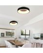 Trio Girona 671210132 sfeerfoto van twee plafonnieres met zwarte rand en lichtgevende ring met geïntegreerde LED boven een eettafel naast een open keuken met kookeiland