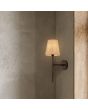 Searchlight Gothic 30690-1BK sfeerfoto van brandende gotische wandlamp met gebutst bruin metalen wandplaat en fakkelvormige lamp met linnen kap aan houtkleurige wandpanelen