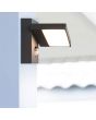 Trio Horton 226369142 sfeerfoto van antraciet grijze wandlamp voor buiten met kantelbaar lichtpaneel en bewegingsmelder