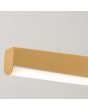 Hoek van de goudkleurige langwerpige hanglamp van 150 cm lang met licht gebogen onderzijde waar LED in geïntegreerd is