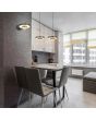Sfeerfoto van Trio Keaton zwarte wandlamp van 18,5 cm hoog met dubbele schijf vormige kap met geïntegreerde led naar beneden in een modern appartement met een dubbele hanglamp uit dezelfde serie