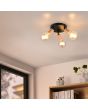Sfeerfoto van Casalum Lamego zwart metalen plafondspot van 29 cm in diameter met drie spots met imitatiehouten fittinghouder en goudkleurige globelamp voor een boekenkast en raam