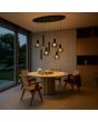 Sfeerfoto van de Brilliant Ligari zwarte hanglamp van 126 cm lang met ovale plafondplaat, vijf bolvormige rookglazen kapen en drie cilindervormige buizen met GU10 spot in een sfeervolle eetkamer boven een marmeren eettafel
