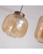 Detailfoto van een glazen kap van de Searchlight Lille hanglamp met koffiebruine plafondbalk van 105cm met vier pendels met ronde en ovale amberkleurige ribbel glazen kappen