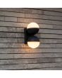 Sfeerfoto van Lutec Looma antraciet grijze wandlamp voor buiten met twee draaibare bolvormige kappen van 10 cm in diameter met wit kunststof zijde met lichtbundels naar boven en beneden