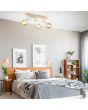 Sfeerfoto van Casalum Lynar plafondspot met houten bevestingsbalk van 42 cm lang en drie wit metalen fittinghouders met goudkleurige globelamp boven een houten bed in een Scandinavian slaapkamer