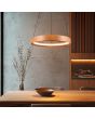 Trio Lynwood 355030130 sfeerfoto van ringvormige houten hanglamp van 50cm met LED rand naar binnen gericht aan drie staalkabels boven een eettafel in een landelijke woonruimte