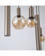 detailfoto van het glas en de kappen van de Searchlight Lyon hanglamp met koffiebruine ovale plafondplaat van 140cm en drie pendels met cilindervormige metalen kappen met GU10 lamp en vijf pendels met amber glazen kappen met E27 fitting