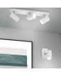 Trio Marley 802400101 sfeerfoto van wit metalen wandspotje met vierkante wandplaat en cilindervormig spotje met GU10 lamp naast een schilderij met een drie spot uit dezelfde serie aan het plafond