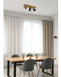 Trio Marley 812400332 sfeerfoto van spot met rechthoekige houten plafondplaat en drie zwarte cilindervormige spotjes met GU10 lampje boven een eettafel met vier grijze kuipstoelen voor een raam met vitrage tot de grond