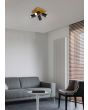 Trio Marley 812400432 sfeerfoto van spot met vierkante houten plafondplaat en vier zwarte cilindervormige spotjes met GU10 lampje in een huiskamer met designradiator en grijze bank